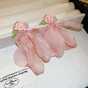 Detail of pink chiffon flower earrings with delicate bead center on a jewelry tray
