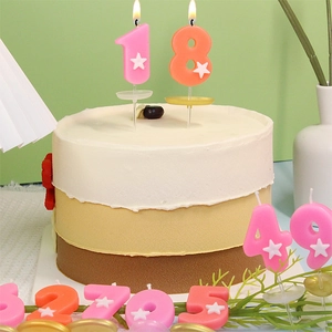 Candeline per compleanno numero 18 rosa e arancione con stelle bianche su una torta