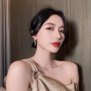 Gros plan de boucles d'oreilles pendantes feuilles dorées portées par un mannequin
