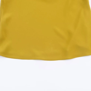 Close-up detail of smooth yellow fabric hem and precision stitching on a women halter top