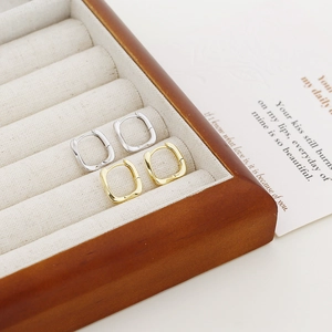 Detail view of square s925 silver geometric hoop earrings in gold and silver finishes
