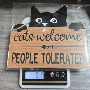 Black cat welcome sign weight measurement on scale showing 91g with rustic jute rope detail