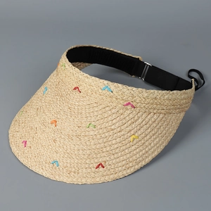 Detail eines Raffia-Sonnenhutes mit bunten V-Stickereien und schwarzem Schweißband