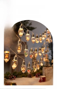 Close-up of LED Christmas wishing bottle lights with mini snowman and Santa figurines
