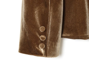 Detalle del puño de blazer de terciopelo marrón con tres botones forrados y textura suave