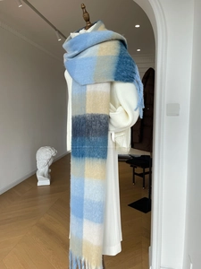 Close-up of thick gradient plaid scarf featuring long tassels and plush texture
