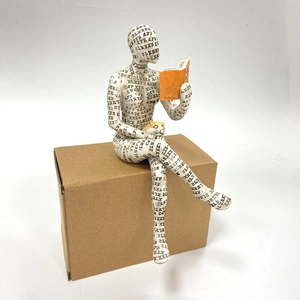 Detailed white resin reading woman figurine with black letters and orange book