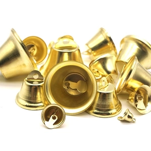 Close-up of assorted glossy gold metal Christmas bells for DIY crafts and decorations