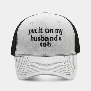 Detail of grey trucker hat featuring black embroidery and breathable mesh back