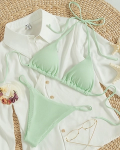 Flat lay of mint green ribbed halter bikini set with starfish and summer accessories