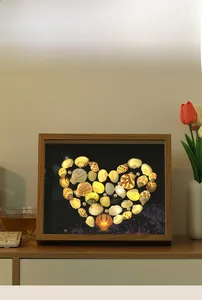 Detail of DIY seashell heart light box with warm LED star background in wooden frame