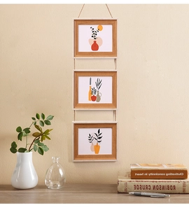 Hanging 3-tier light wood picture frames with rustic hemp rope on a textured wall