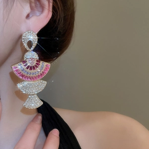 Close-up of fan-shaped fan earrings with pink and purple gemstones and sparkling crystals