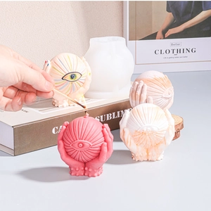 Detail of hands holding eyeball silicone mold and DIY handmade scented candles