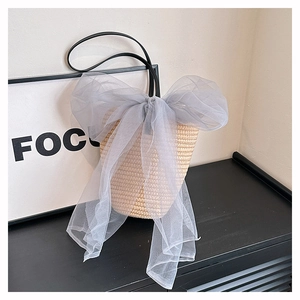 Straw bucket bag in beige weave with a grey organza bow and slim black strap