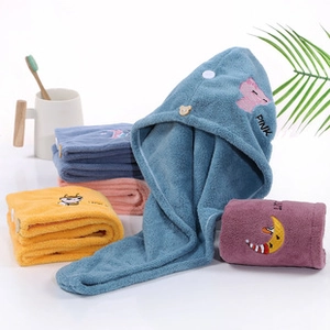 Close-up of soft coral fleece towel with cute bear button and pink embroidery detail