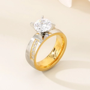 Macro detail of a four-prong diamond ring featuring gold and silver brushed metal finishes