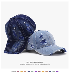 Detail of distressed ripped denim baseball cap showing vintage washed texture and frayed edges