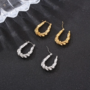 Boucles d'oreilles créoles torsadées en acier inoxydable doré 18K et argenté sur fond noir