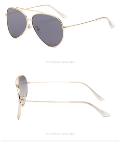 Detail view of gold aviator sunglasses with dual-bridge and gray lenses