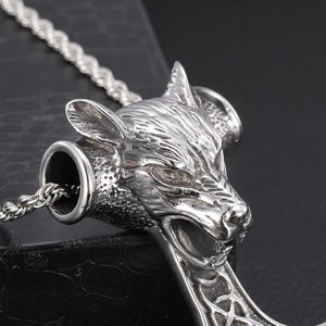 Vue rapprochée d'un pendentif tête de loup en acier inoxydable argenté aux détails fins