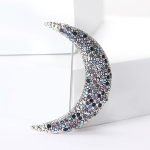 Macro shot of silver crescent moon brooch with purple and blue gradient rhinestones