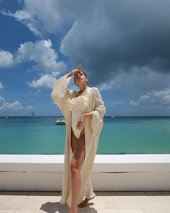 Close-up of cream one-piece swimsuit featuring 3D floral accents and sheer resort cover-up