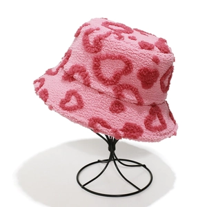 Close-up of pink faux fur bucket hat with embroidered heart pattern and soft texture