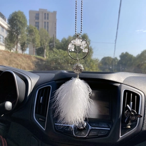Detail of white feather car dreamcatcher with crystal tree and silver hollow bell charm