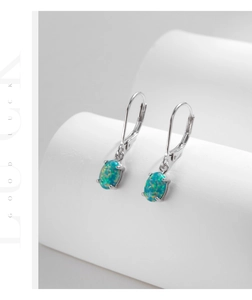 Detailed macro view of oval opal drop earrings with secure silver four-prong setting
