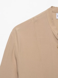 Detailed macro view of khaki chiffon shirt collar with textured crepe fabric and button holes