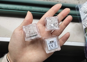 Close-up of three LED flashing ice cubes showing bottom CE certification and labels