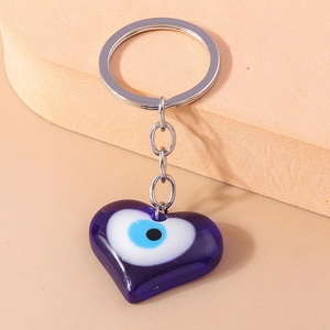 Macro shot of blue heart-shaped evil eye pendant with silver metal keyring and chain