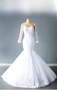 Detail of white mermaid wedding dress with lace sleeves and floral sequin embroidery