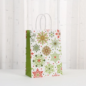 White Christmas kraft paper gift bag with red and green snowflake patterns and handles