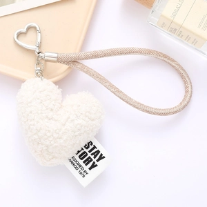 Detailed macro view of a beige plush heart pendant with woven rope and metal clasp