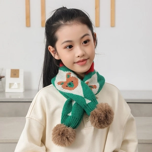 Détail de l'écharpe en tricot verte pour enfants avec motif ours et pompons doux