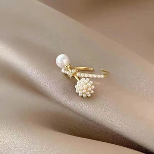 Elegant gold pearl ring with crystal accents on a soft satin background