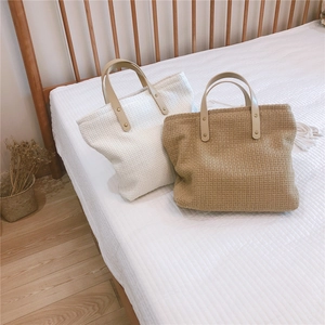 Detail of waffle weave fabric tote bags with faux leather handles and metal rivets