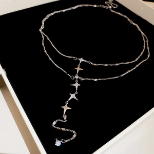 Detailed view of silver double-layer star necklace with rhinestones on black velvet
