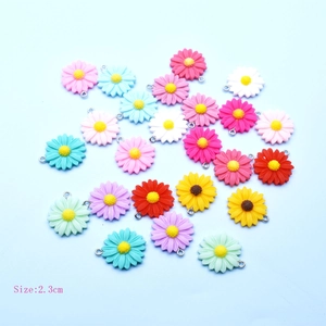 Colorful resin daisy charms in pink, blue, and yellow with metal loops for DIY jewelry