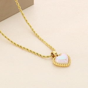 Close-up of golden twisted chain necklace with a pearlescent heart pendant and beaded edges