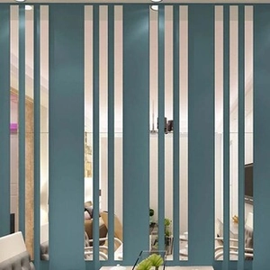 Detailed view of self-adhesive teal and mirror mosaic strips on a modern living room wall