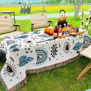 Close-up of Bohemian picnic blanket featuring colorful tassels and woven cactus patterns