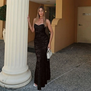 Dettaglio dell'abito lungo in pizzo nero con spalline sottili e silhouette sciancrata