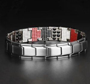 Macro detail of silver magnetic therapy bracelet with inset health elements on black background