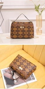 Detail shot of brown quilted crossbody bag with clover print and double zipper
