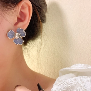 Detail of elegant lavender flower stud earring featuring silver petals and textured finish