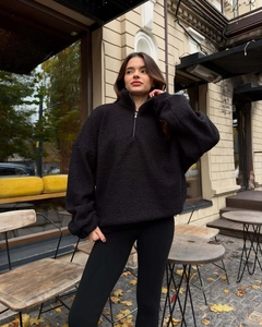 Detail of black oversized sherpa fleece sweatshirt with half-zip collar and cozy texture