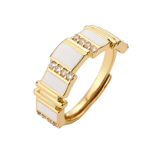 Macro shot of gold-plated geometric ring with white enamel and micro-pave cubic zirconia